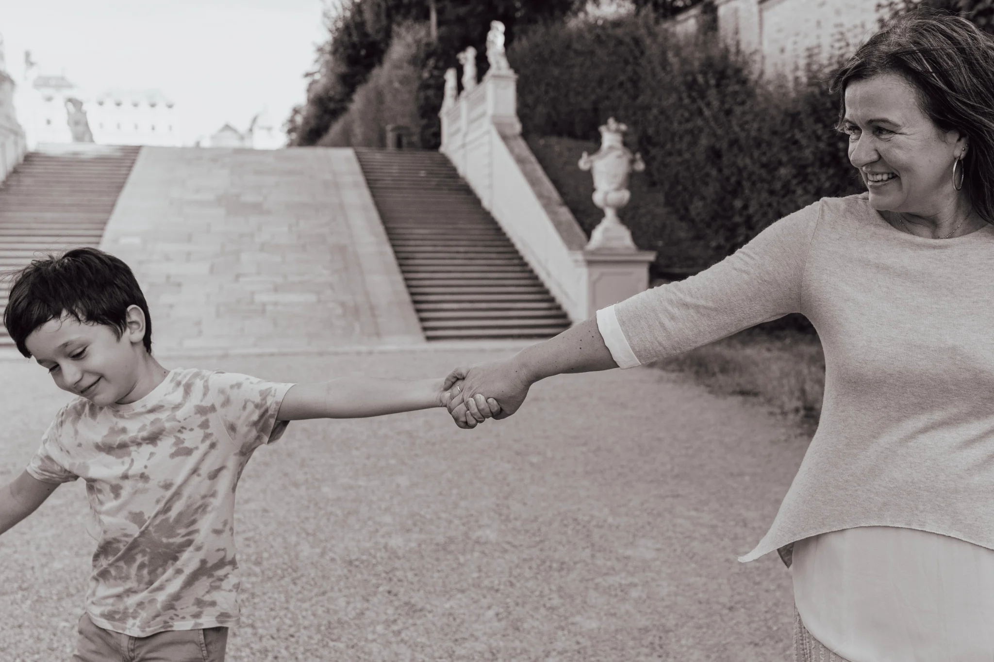 Mother and son holding hands in front of the steps at the Belvedere Gardens.