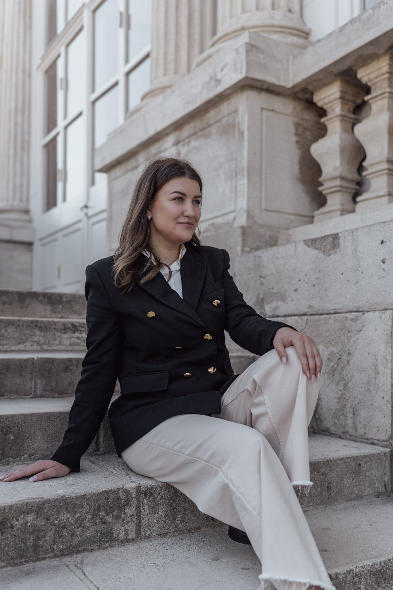 Mladá žena sedící na schodech Gloriette v zámeckém parku Schönbrunn ve Vídni.
