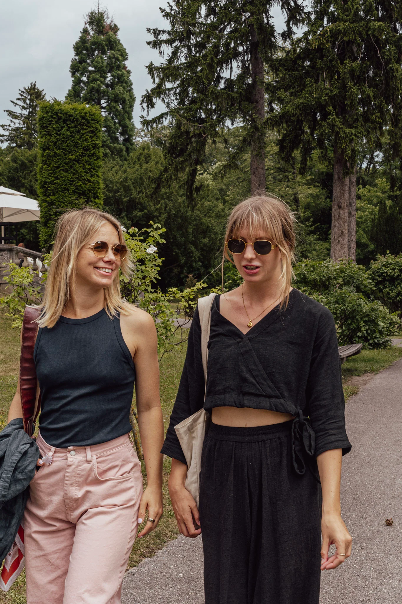 Young women walking through a park, chatting together.